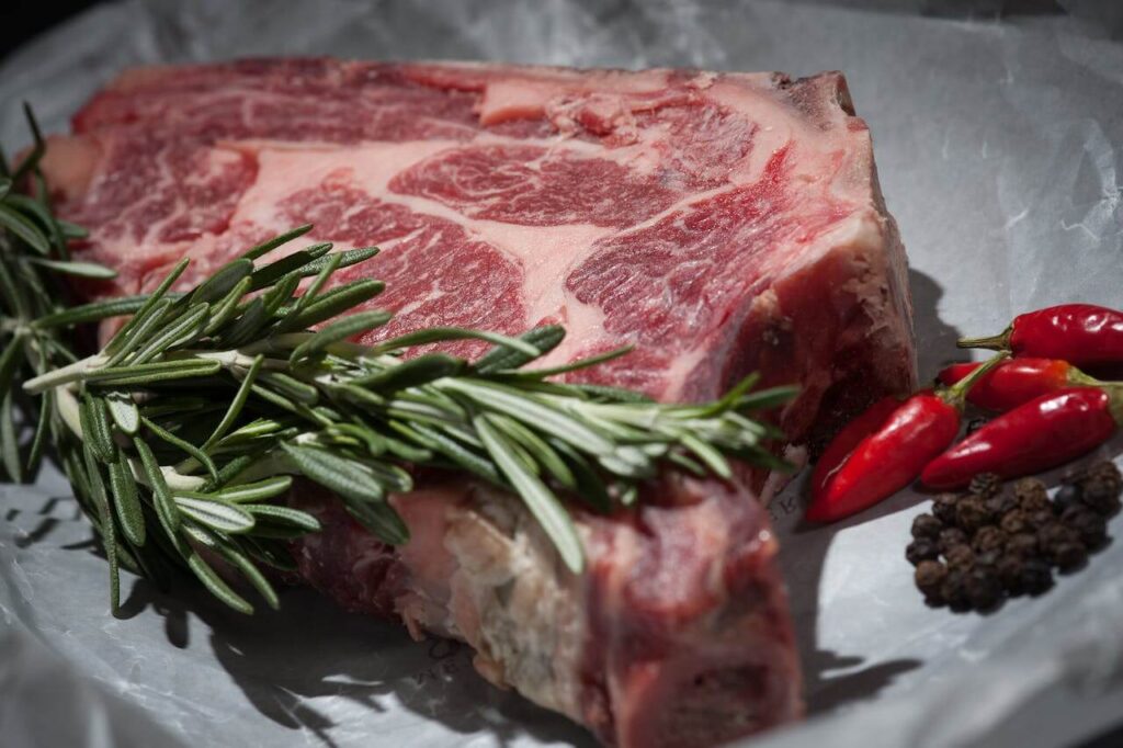 how should raw meats be shelved prior to cooking